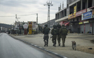 توضيحية: جنود إسرائيليون في دورية في بلدة حوارة الفلسطينية المضطربة، 12 نوفمبر، 2023. (AP Photo/Mahmoud Illean)