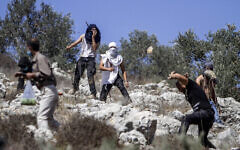توضيحية: مستوطنون إسرائيليون يرشقون فلسطينيين الحجارة بالقرب من مستوطنة يتسهار الإسرائيلية في الضفة الغربية، 7 أكتوبر، 2020. (Nasser Ishtayeh/Flash90)