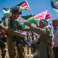 ملف: جنود إسرائيليون يقفون للحراسة خلال مظاهرة لفلسطينيين ونشطاء من اليسار في قرية بيت دجن بالضفة الغربية، 30 يونيو، 2023. (Nasser Ishtayeh/Flash90)