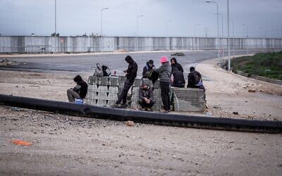 عمال فلسطينيون من الضفة الغربية ينتظرون لأصحاب العمل في حاجز "أيال" بالقرب من قلقيلية، 20 فبراير 2022 (AP Photo/Oded Balilty)