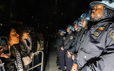 طلاب وناشطون مناهضون لإسرائيل يواجهون ضباط الشرطة أثناء احتجاجهم على الحرب بين إسرائيل وحماس في حرم جامعة نيويورك في نيويورك، 22 أبريل 2024. (Photo by Alex Kent / AFP)