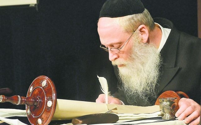 Rabbi Moshe Klein, shown during the March completion of a Torah for Chabad of Cobb, leads a team of seven sofrim (scribes) at eSofer.com.