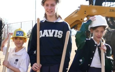 Second-grader Benjamin Barkan, eighth-grader Abigail Barkan and fifth-grader Miriam Barkan, representing the present and future of the Davis Academy and the Davis family, get their turn with the shovels at the groundbreaking.