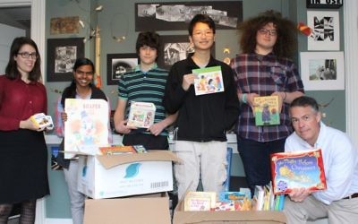 Teachers Mary Catherine Stoumbos and Edward Ellis flank Ben Franklin students (from left) Sophie Morris, Alex Warren, Ben Chen and Declan Greenwald with the donated books.
