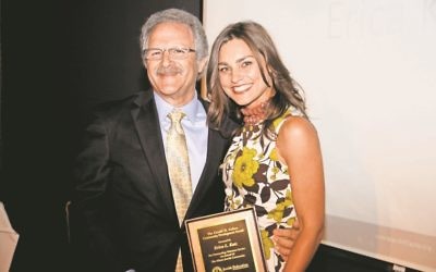 Michael Horowitz, at his final Federation annual meeting as CEO in June, presents the Gerald H. Cohen Community Development Award to volunteer Erica Katz. Horowitz’s final day on the job was in February.