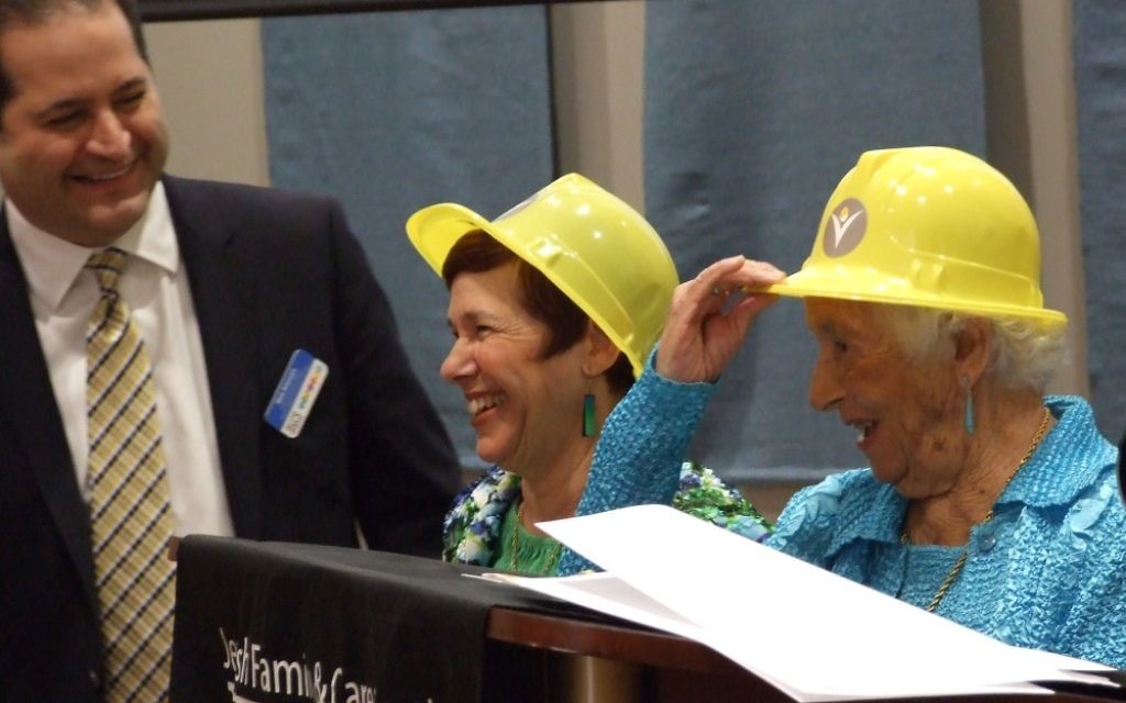 Frances Bunzl (right) and daughter Suzy Bunzl Wilner try on their ceremonial hard hats at the JF&CS annual meeting with agency CEO Rick Aranson.