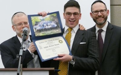 Rabbi Shimon Wiggins (left) and Rabbi Yechezkel Freundlich flank new graduate Naftali Maman.