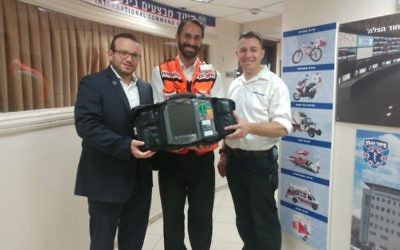 Former Atlantan Arie Pelta (center) on Aug. 28 receives the advanced defibrillator Atlanta donors paid for.