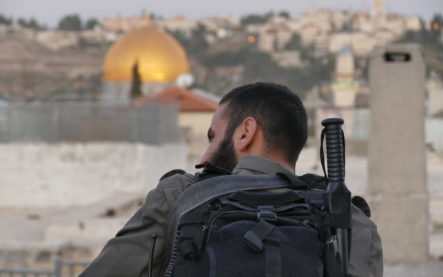 A soldier overlooks the dome of the rock in the old city of Jerusalem.