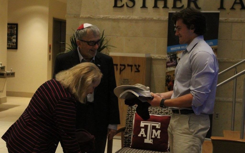 Student activities director at Texas A&M Hillel
Weber School graduate and Texas A&M kinesiology sophomore Joshua Williams presents Aggie gear to Holocaust survivors Thomas Gabor and his wife, Danielle.