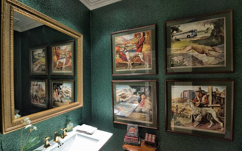 The guest bathroom displays a set of four vintage posters from the Greyhound Bus Co. and wallpaper made of roofing material. (All Photos by Duane Stork).