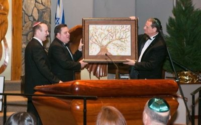 Etz Chaim President Todd Surden and past President Scott Rittenberg president the congregation’s gift of a Tree of Life painting to Rabbi Daniel Dorsch.