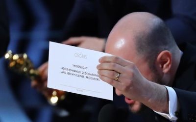 Producer Jordon Hurwitz holds up the card for the Best Picture winner Moonlight.