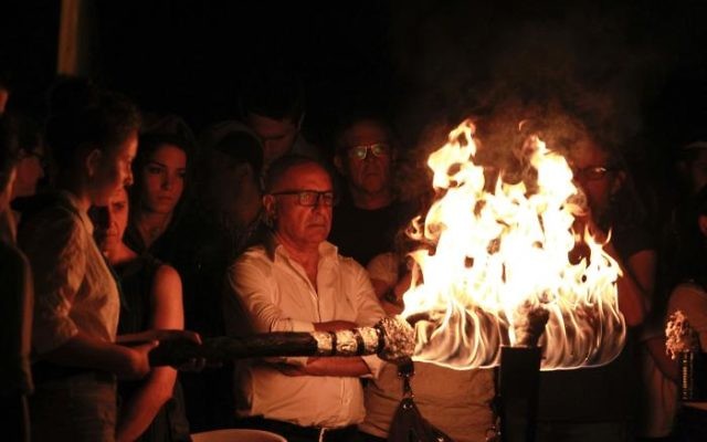 An Israeli lights one of the 12 torches for Independence Day on Mount Herzl