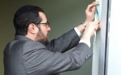Rabbi Joshua Heller, one of the two honorees March 16, hangs the MACoM mezuzah at the opening ceremony in November 2015.