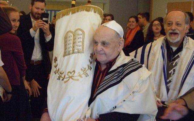 Bar mitzvah man Leon Asner carries the Torah before his first aliyah.