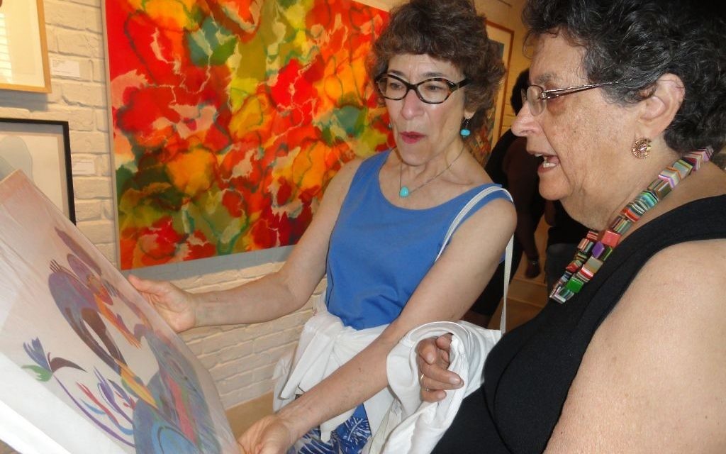 Flora Rosefsky (right) discusses one of her pieces at the Different Trains Gallery opening. (Photo by Kevin C. Madigan)