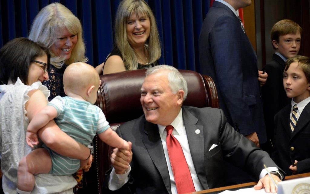 Gov. Nathan Deal makes a friend at the signing ceremony for the Hearing Aid Coverage for Children Act on May 8.