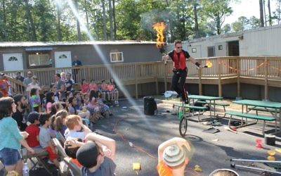 Rather than a bonfire, one man on a unicycle handles the flames.