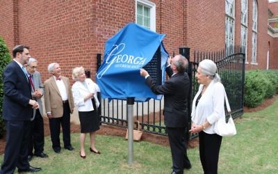 W. Todd Groce uncovers the historical marker in front of (from left) Senior Rabbi Peter Berg, Rabbi Emeritus Alvin Sugarman, Tony and Jackie Montag, and Janice Rothschild Blumberg.