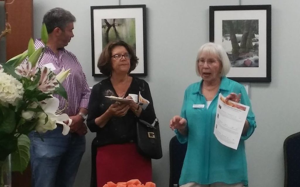 Artist Margery Diamond (right), speaking at the opening of her MACoM exhibit, says her latest camera is a Fujifilm mirrorless digital camera, but great photography is possible even with smartphones.