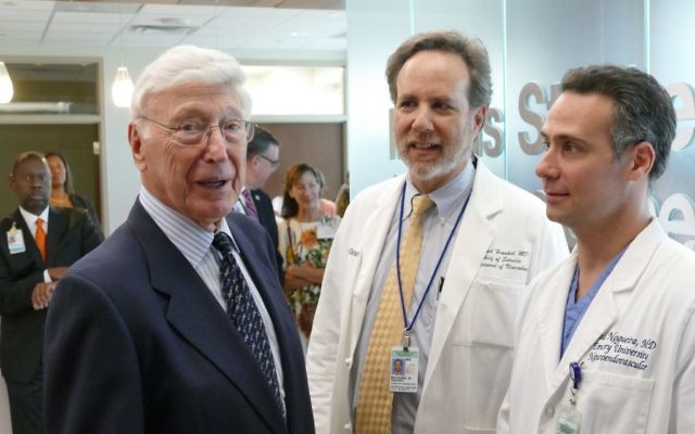 Bernie Marcus speaks with Michael Frankel (center), the chief of neurology and medical director of the Marcus Stroke & Neuroscience Center, and Raul Nogueira, the director of the center’s neuroendovascular division.