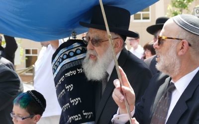 Rabbi Emanuel Feldman carries the new Torah into Beth Jacob.