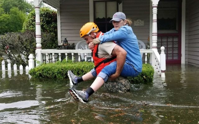 A Texas National Guardsman carries a resident from her flooded home following Hurricane Harvey in Houston. (Photo: U.S. Department of Defense)