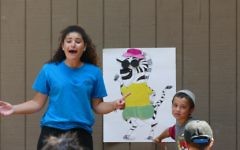 Israeli counselor Sapir Beresi leads campers in the Marcus JCC’s Hebrew immersion day camp program in a game in which they must put articles of clothing on a zebra and say the items’ names in Hebrew.