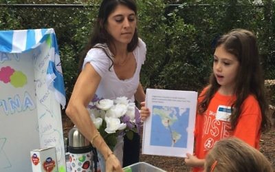 Giselle Gryngarten and second-grader Luana Etchechoury share Shabbat customs from Argentina, including alfjores de maicena, a cookie sandwich filled with dulce de leche and covered with shredded coconut or sprinkles.