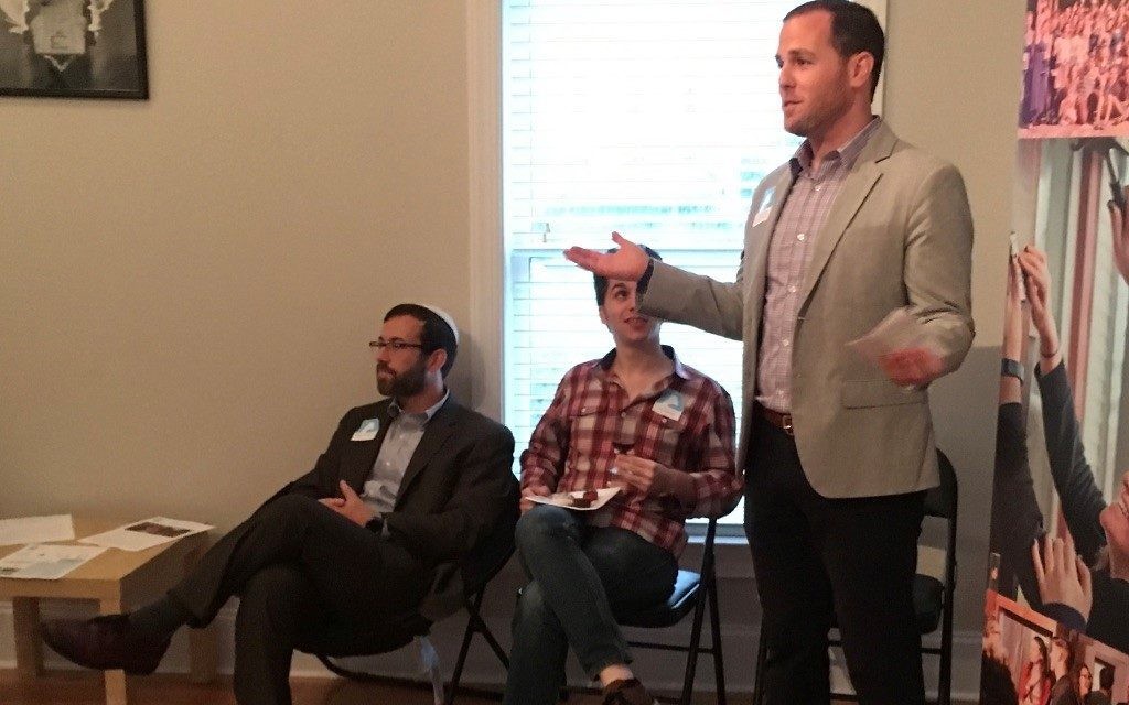 While his fraternity brother, Congregation Shearith Israel Rabbi Ari Kaiman, and Eli Harrison listen, Lander Gold, the senior director of advancement and philanthropic partnerships for Moishe House, tells about the organization’s origins in 2006 in Oakland, Calif., when three friends decided to hold a Shabbat dinner and ended up hosting more than 70 young adults.