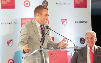 ESPN soccer analyst and former U.S. national team player Taylor Twellman gets a smile out of Atlanta United owner Arthur Blank at the Oct. 23 news conference announcing that MLS is bringing its All-Star Game to Mercedes-Benz Stadium next year. (Photo by Itoro Umontuen)