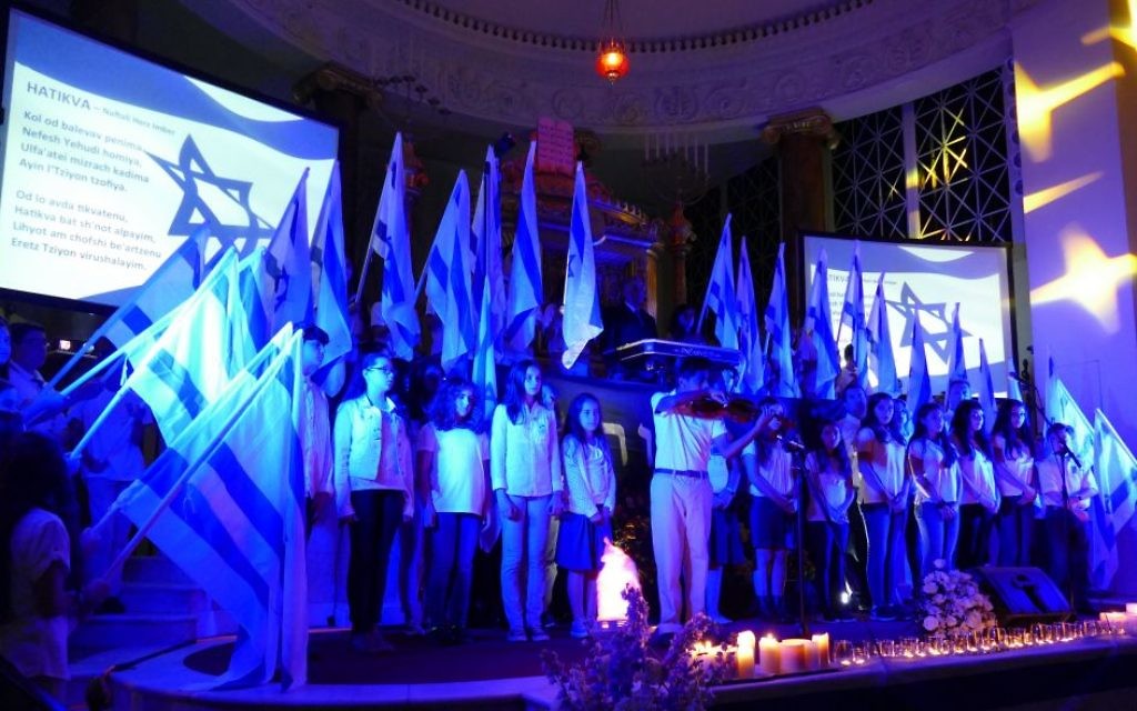 Israel Scouts hold Israeli flags during the singing of “Hatikva” at the conclusion of the community Yom HaZikaron ceremony April 30, 2017, at The Temple.