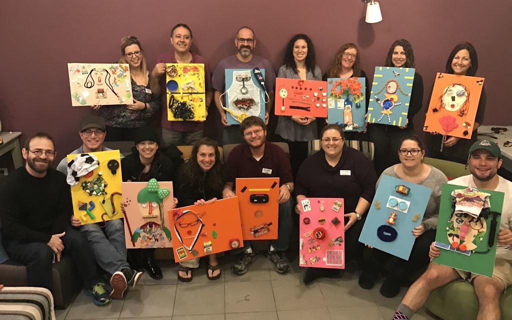 Participants in the JumpSpark Professional seminar in Israel show the self-portraits they made with found materials. Seated (from left) are artist Hanoch Piven; Ezra Flom, the director of youth and family programming at Temple Kol Emeth; Nicole Andronescu Flom, the assistant director of education at Ahavath Achim Synagogue; Bobbee Griff, the youth adviser at Temple Beth Tikvah; Adam Griff, the regional director of youth engagement for NFTY-SAR; Elizabeth C. Foster, a family and teen educator at The Temple; Molly Okun, the director of youth and teen engagement at Temple Sinai; and Jason Price, a program manager for the Atlanta Jewish Teen Initiative. Standing (from left) are Hope Chernak, the executive director of the Atlanta Jewish Teen Initiative; Rabbi Gabby Dagan of the Leo Baeck Education Center; Rich Walter, the associate director for Israel education at the Center for Israel Education; Hannah Zale, the music director for In the City Camp and a religious school music educator and youth adviser at Congregation B’nai Torah; Susan Cosden, the director of education at Temple Beth Tikvah; Jody Gansel, a program manager for the Experiential Jewish Education Network; and Mira Hirsch, an artistic associate for Theatrical Outfit Project Tolerance at The Temple.
