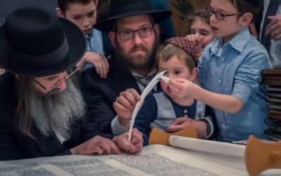 Rabbi Mendy Gurary helps write the last letter on the new Sephardic Torah dedicated in memory of Reuven Manoah.