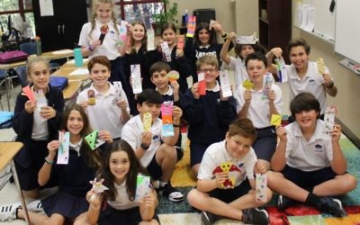 Davis Academy sixth-graders show the bookmarks they received from Russia.