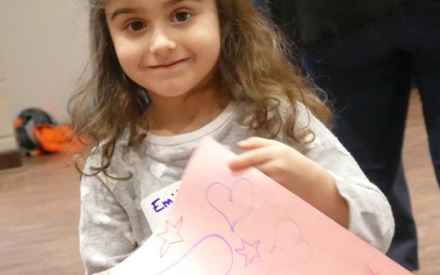 One young volunteer shows off the card she created.