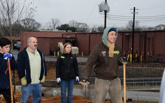 Greg Levine (right), the co-executive director and chief program officer of Trees Atlanta, sets an example for the volunteers.