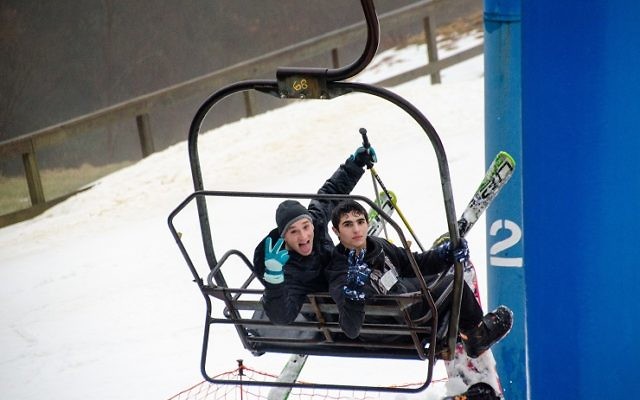 Yehuda Deutsch (left) and Tzvi Cavalier head up the ski lift for another run. (Photo by Eli Gray)
