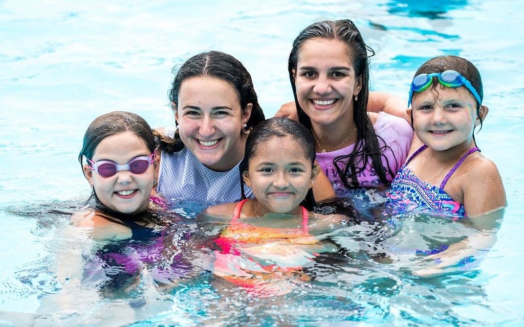Counselors Emily, 25, and Sophie, 22, swim with campers Keira, 10, Genesis, 11, and Kaitlyn, 10, at Sunrise Day Camp-Long Island.