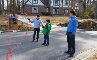 Micah Bronfman (left) helps Sammy Lesser with a kite while Yaniv Zigmond stands by during a recent Sunday playdate in the Friends@Home program.