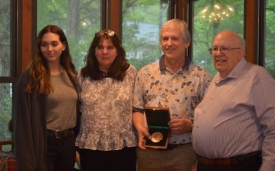 Sister Madison Zinsenheim and parents Penny and Steve Zinsenheim accept the Carnegie Medal in memory of Davis Zinsenheim from past recipient Charlie Harris on April 22. (Photo courtesy of the family)