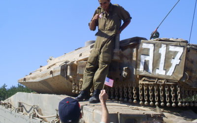 Scott Allen, wearing an Atlanta Braves hat, gives an American flag to an Israeli soldier during the Second Lebanon War in 2006.