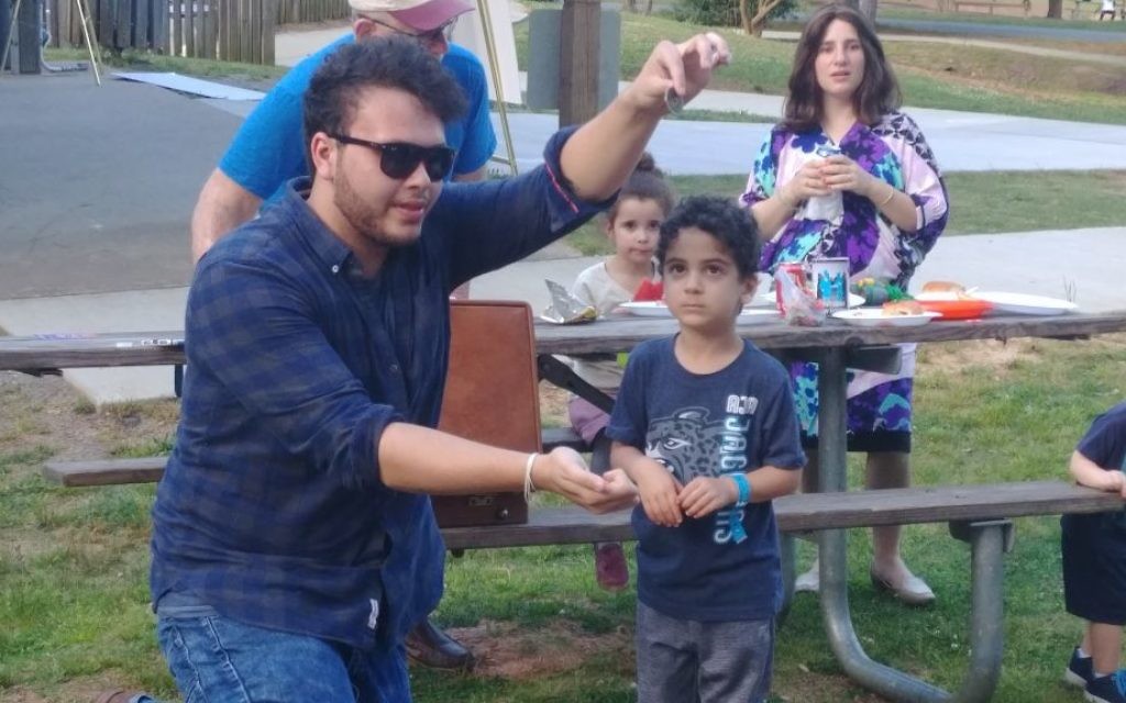 A magician keeps the young crowd mesmerized at East Cobb Park during Chabad of Cobb's Lag B'Omer picnic Thursday, May 3.