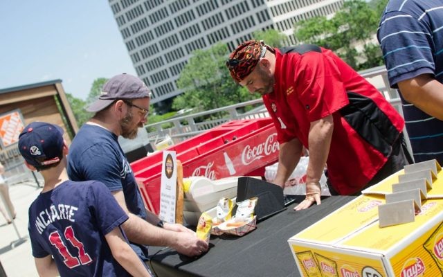 Keith Marks of Keith’s Corner BBQ serves Kosher Day customer Brett Cohen at the Braves game May 6. (Photo by Eli Gray)