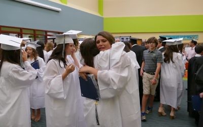 Ava Stark and Jessie Schulhof share a goodbye hug before they leave for high school.