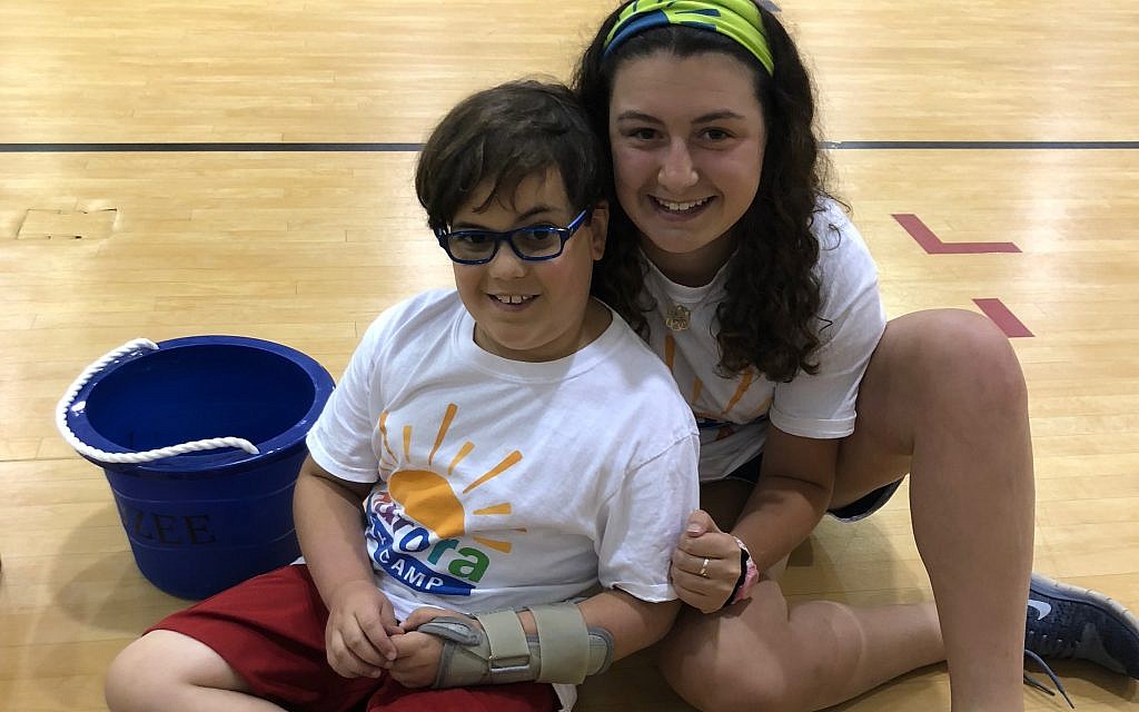 Counselor Jenna Grossman, a Davis Academy graduate, works with children with cancer, such as the one pictured, along with their siblings.