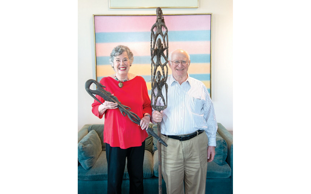 Ray Ann Kremer and George Shapiro hold primitive wood artifacts in front of paintings by Ida Kohlmeyer (Tulane/Newcomb professor) and Burton Callicott (Cloud Bands, 1974), a former professor at the Memphis Academy of Art. //Photos by Duane Stork
