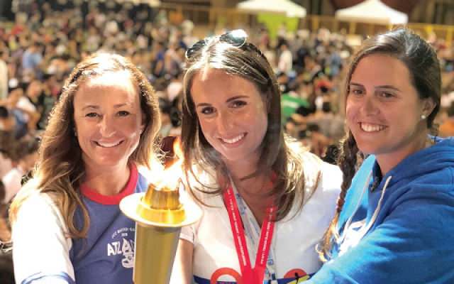 Passing  the  JCC  Maccabi  Games  torch  during  the  closing  ceremonies  in  Orange  County,  Calif.,  on  August  9,  2018  are  (L-R):  Stacie  Francombe,  2019  Atlanta  Games  Director;  Sam  Cohen,  2018  Orange  County  Games  Director;  Carissa  Mindt,  2019  Atlanta  Games  Assistant  Director.