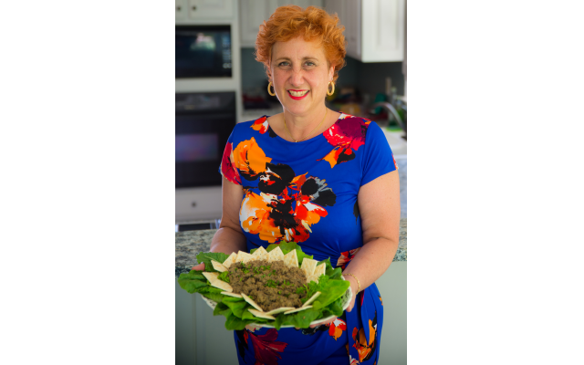 Phot by Robert Hainer// Terri Hitzig proudly holds a tray of her Hungarian grandmother Elsie's chopped liver, garnished with leafy greens and served with saltines.